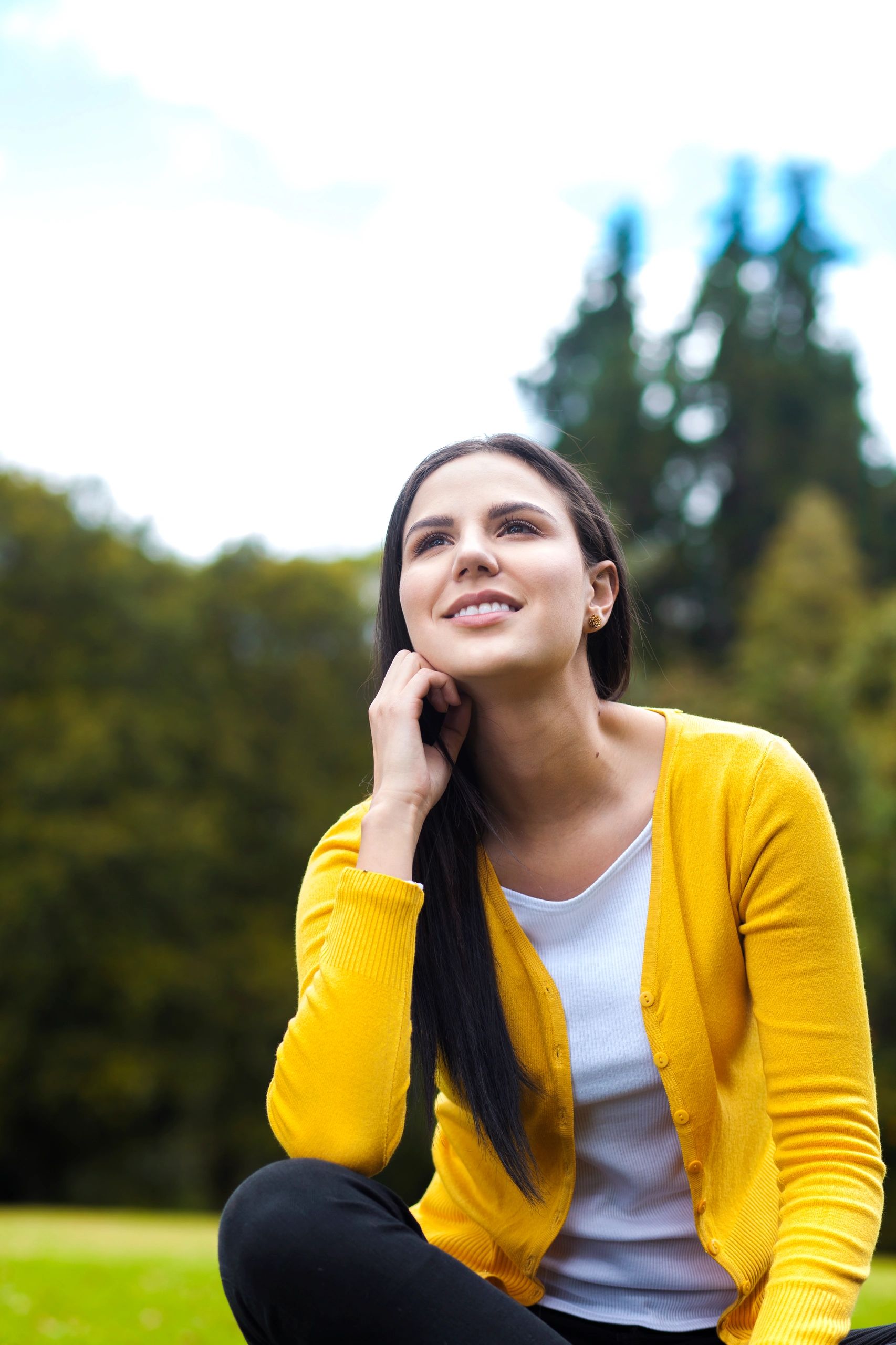 Woman sitting outdoors in nature reflecting